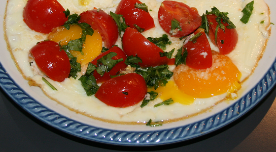 Uova all'occhio di bue con pomodorini, rucola e grana